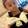 toddler, child, baby, black_dress, white_bow, hair_bow, bed, plush_toys, stuffed_animals, indoor, portrait, cute, smiling, person, young_child, cozy, window, natural_light, bedroom, decor