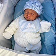 Kozhin joined the competition — help win amazing prizes! newborn, baby, sleeping, knit_hat, white_clothing, mittens, blue_cushion, feather_pattern, soft_texture, cozy, infant, resting, portrait, cute, peaceful, indoors, baby_bib, closeup, blanket, crib