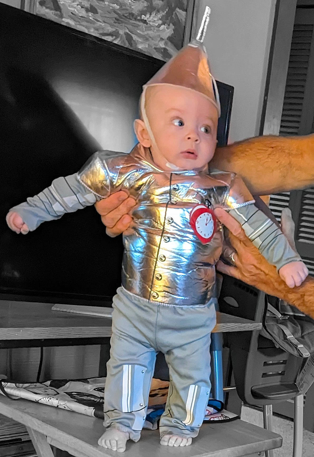 Oliver is registered to the contest to win money with this photo: action_figure, baby, belt, carmine, chair, child, costume, fictional_character, figurine, flooring, fun, gesture, machine, person, personal_protective_equipment, sitting, surprise, thumb, toddler, toy