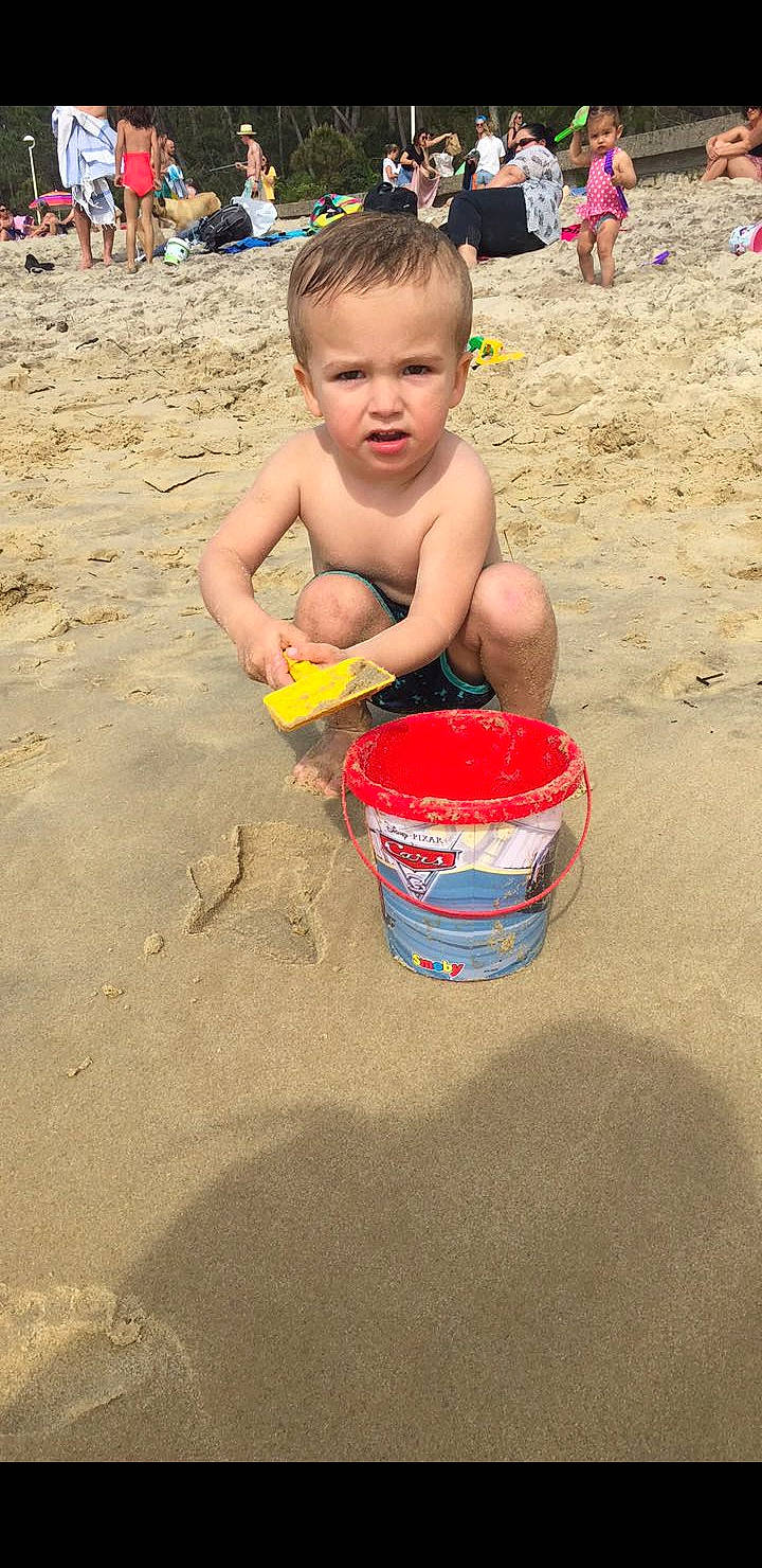 Wassim participe au concours pour gagner de l'argent avec cette photo : ball, barechested, barefoot, beach, blurred, bucket, child, foot, fun, leisure, ocean, people_on_beach, person, play, recreation, sand, shorts, sitting, soil, toddler