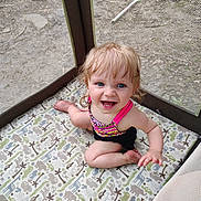 Renesmee joined the competition — help win amazing prizes! toddler, child, playpen, mesh, animal_pattern, blue_eyes, blond_hair, smiling, happy, sitting, outdoor, toy, racket, colorful_clothing, pink_strap, barefoot, padded_floor, baby, young_child, curly_hair