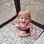 toddler, child, playpen, mesh, animal_pattern, blue_eyes, blond_hair, smiling, happy, sitting, outdoor, toy, racket, colorful_clothing, pink_strap, barefoot, padded_floor, baby, young_child, curly_hair