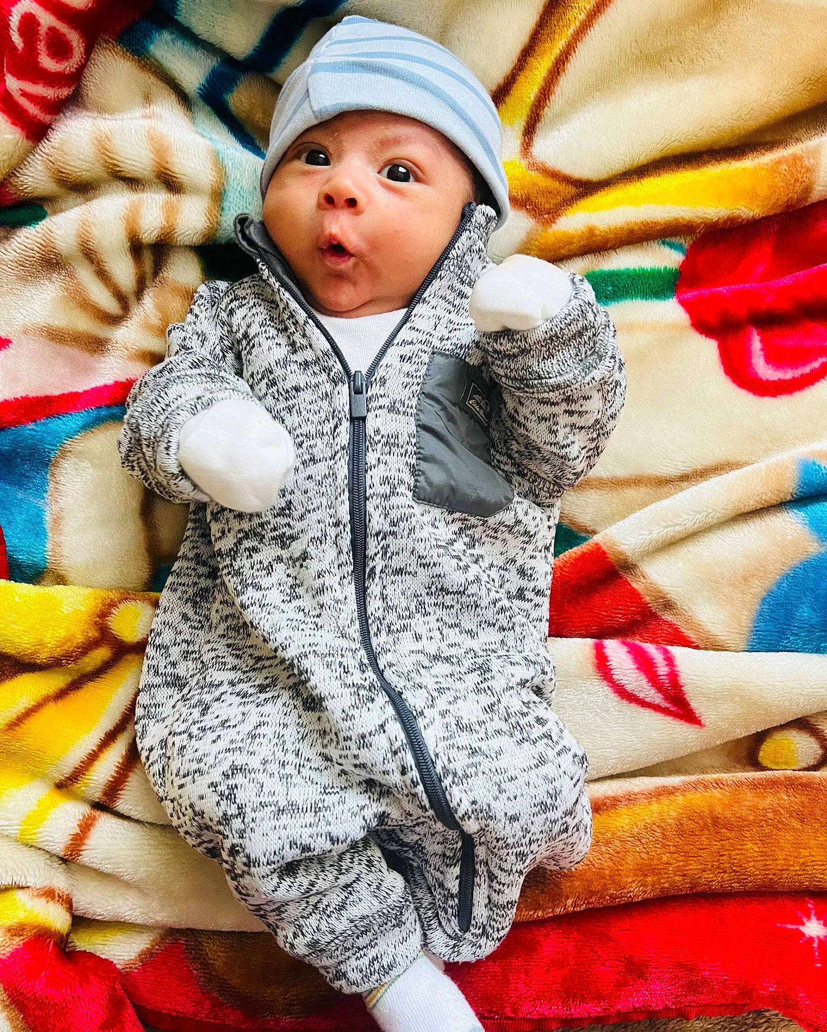 Austin is registered to the contest to win money with this photo: baby, baby_toddler_clothing, cap, child, comfort, fashion_accessory, fun, fur, happy, headgear, headwear, knit_cap, linens, outerwear, pattern, person, sitting, sleeve, textile, toddler