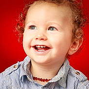Alan a rejoint le concours — aidez-le/la à gagner de superbes lots ! toddler, child, curly_hair, smiling, blue_eyes, necklace, striped_shirt, portrait, happy, closeup, face, red_background, cute, baby, innocent, young_child, casual_clothing, studio_photo, joy, cheerful