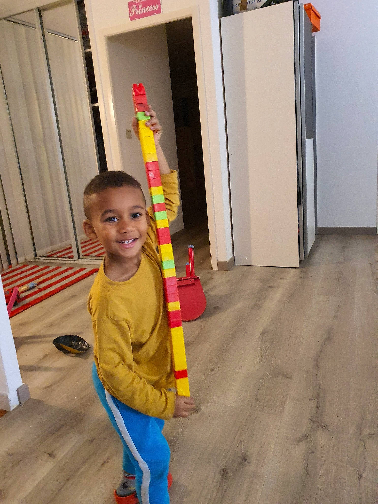 Marshall participe au concours pour gagner de l'argent avec cette photo : child, door, floor, flooring, hardwood, joy, person, play, standing, toddler, wood, yellow