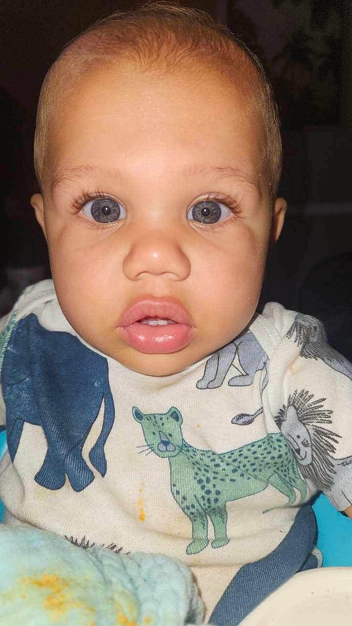 Marquis Junior is registered to the contest to win money with this photo: baby, child, blue_eyes, onesie, animal_print, close_up, curious, plush_blanket, indoor, face, portrait, infant, cute, clothing, person, young_child, soft_lighting, expression, human, toddler