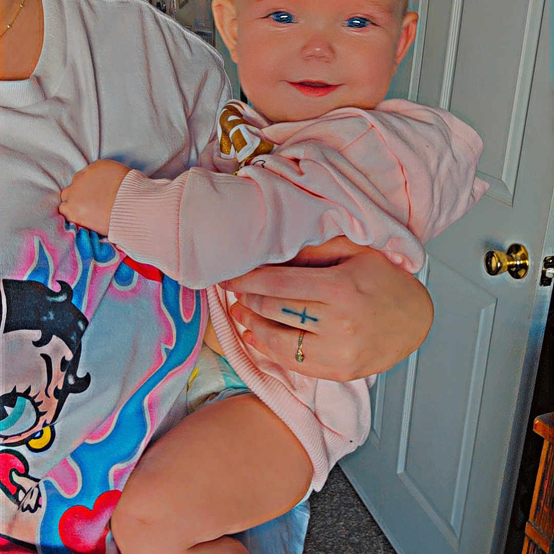 Lilyanna joined the competition — help win amazing prizes! adult, arm, baby, carpet, child, door, face, foot, furniture, glasses, hand, indoor, leg, person, pink_hoodie, ring, smile, tattoo, tshirt, wall_art