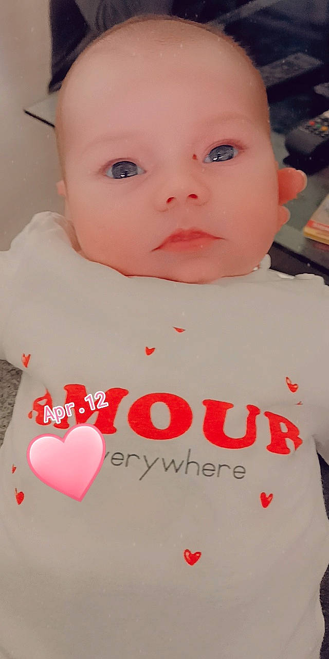 Kenza a rejoint le concours — aidez-le/la à gagner de superbes lots ! baby, baby_toddler_clothing, cheek, chin, eyelash, facial_expression, happy, human_body, lip, mouth, neck, nose, organ, person, pink, red, skin, sleeve, t_shirt, toddler