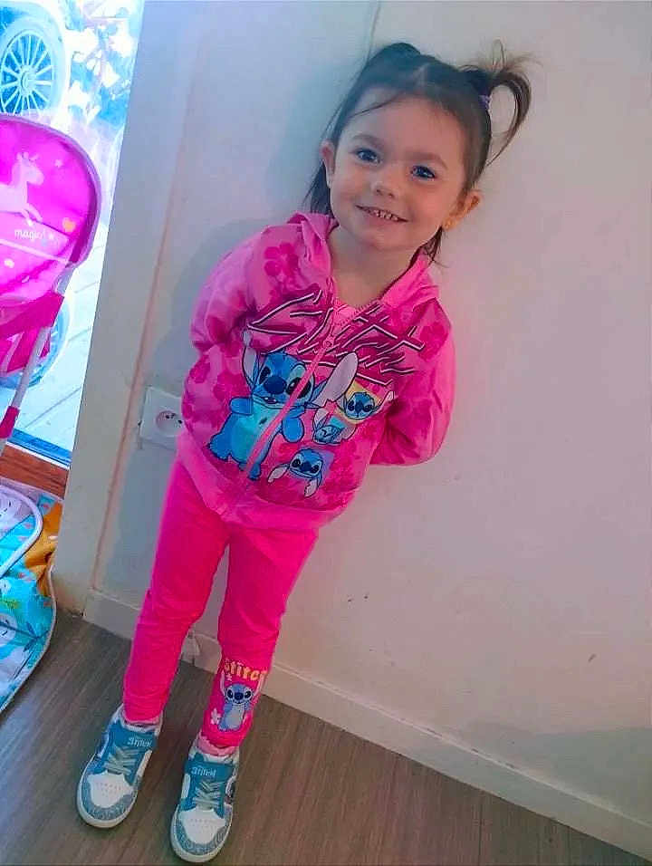 Kenza participe au concours pour gagner de l'argent avec cette photo : blue_shoes, chair, child, cute, floor, footwear, girl, hair_tied, happy, hoodie, indoor, pants, person, pink_clothing, playful, smiling, standing, toy, unicorn, wall