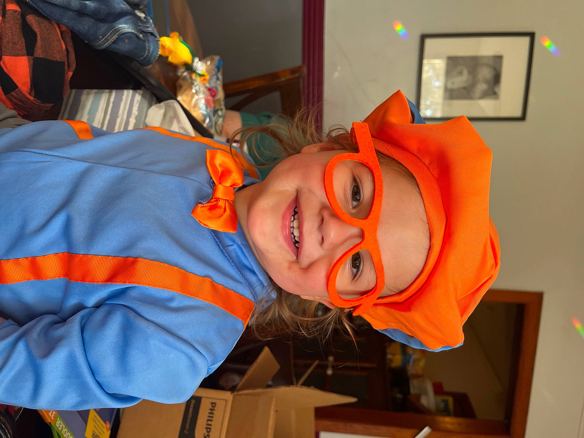 Shepherd is registered to the contest to win money with this photo: art, child, costume, electric_blue, event, fun, hat, headgear, headwear, joy, orange, person, personal_protective_equipment, picture_frame, room, smile, toddler