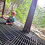 Carson joined the competition — help win amazing prizes! barefoot, bridge, casual_clothing, child, curious, daylight, exploration, forest, greenery, metal_grate, nature, netting, outdoor, safety_net, shorts, sitting, toddler, trees, tshirt, young_child