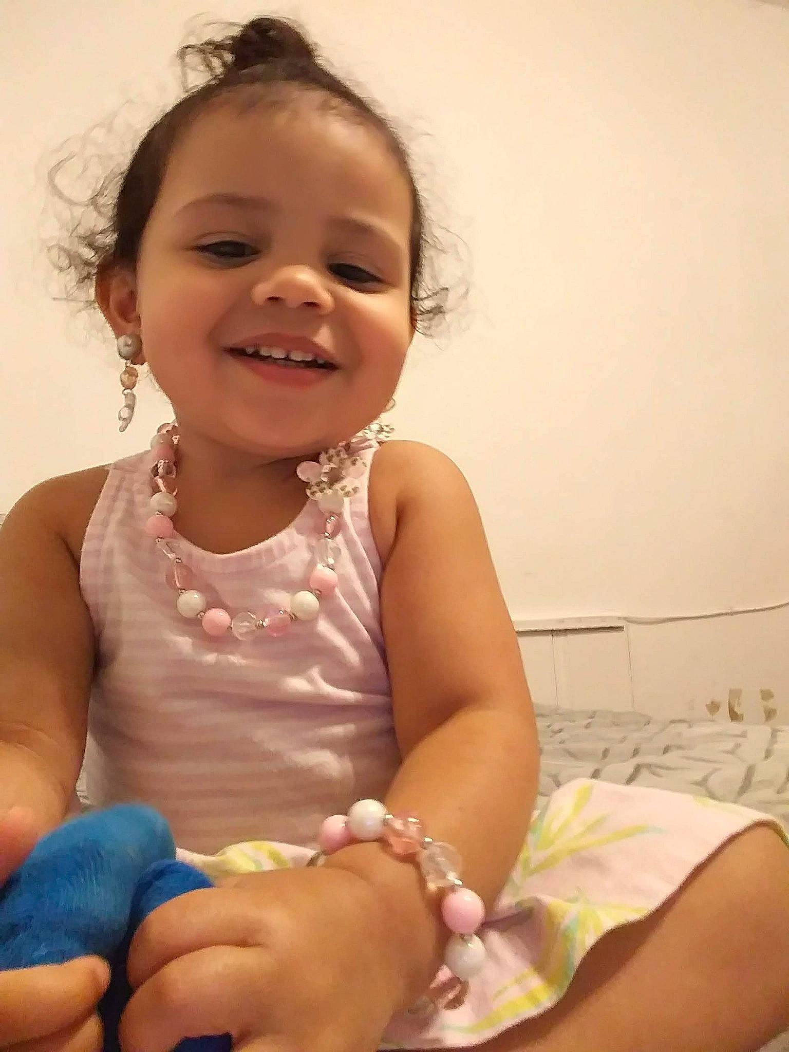 Ivey is registered to the contest to win money with this photo: arm, baby, cheek, child, daughter, face, facial_expression, fashion_accessory, happy, joy, leg, person, sitting, skin, smile, toddler