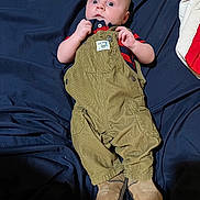 Bodhi joined the competition — help win amazing prizes! baby, bodypart, clothing, coat, couch, face, finger, footwear, furniture, hand, head, jacket, jeans, pants, person, photography, portrait, shoe, shorts, sitting