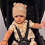 baby, baby_clothes, bear_ears, beige, child, clothing, cute, cute_hat, expression, hat, indoor, infant, knit_hat, person, portrait, seatbelt, serious_face, sitting, stroller, young_child