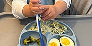 Sandro participe au concours pour gagner de l'argent avec cette photo : baby, bib, broccoli, child, closeup, cute, eating, egg, feeding, food, high_chair, indoor, kitchen, mealtime, messy, person, plate, spoon, table, toddler