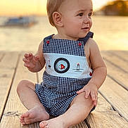 Kamden is registered to the contest to win money with this photo: baby, beachwear, bodypart, clothing, dress, face, finger, hand, head, nature, outdoors, pants, person, photography, portrait, shorts, sitting, water, waterfront, wood