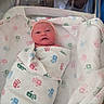 Mackenzie joined the competition — help win amazing prizes! newborn, baby, hospital_bassinet, blanket, handprint_pattern, swaddled, pink_hat, infant, sleeping, bed, hospital, person, cute, wrapped, resting, small, newborn_care, baby_bedding, soft, peaceful