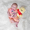 Mackenzie is registered to the contest to win money with this photo: baby, infant, smiling, mickey_mouse, orange_clothing, plush_toy, winnie_the_pooh, soft_toy, lying_down, white_background, fluffy_surface, cute, child, portrait, happy, baby_clothes, toy, cuddly, resting, indoors