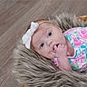 Mackenzie joined the competition — help win amazing prizes! baby, infant, headband, bow, floral_clothing, basket, fur_blanket, wooden_floor, hand_in_mouth, cute, portrait, child, soft_texture, cozy, pink, blue, white, looking_up, resting, indoors