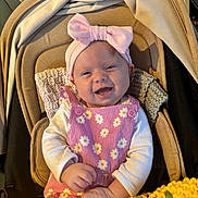 Sofia joined the competition — help win amazing prizes! baby, smiling, pink_bow, pink_dress, floral_pattern, stroller, blanket, knitted_blanket, yellow_blanket, cushion, infant, happy, child, headband, clothing, portrait, indoors, cute, baby_girl, seated