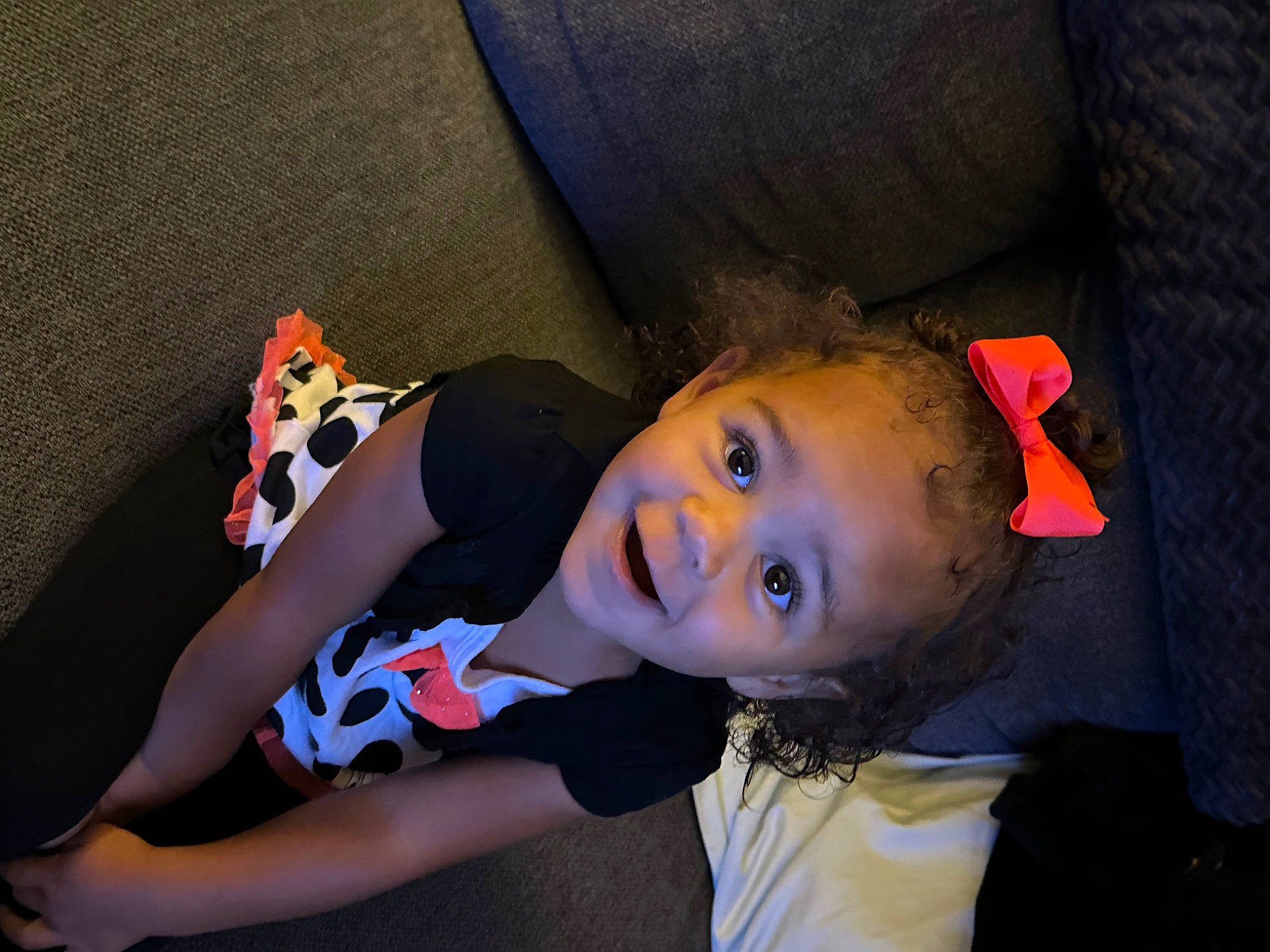 Ava is registered to the contest to win money with this photo: black_hair, child, darkness, electric_blue, fashion_accessory, flash_photography, fun, grass, happy, hat, human_leg, lip, mouth, nose, pattern, person, portrait_photography, sitting, smile, textile