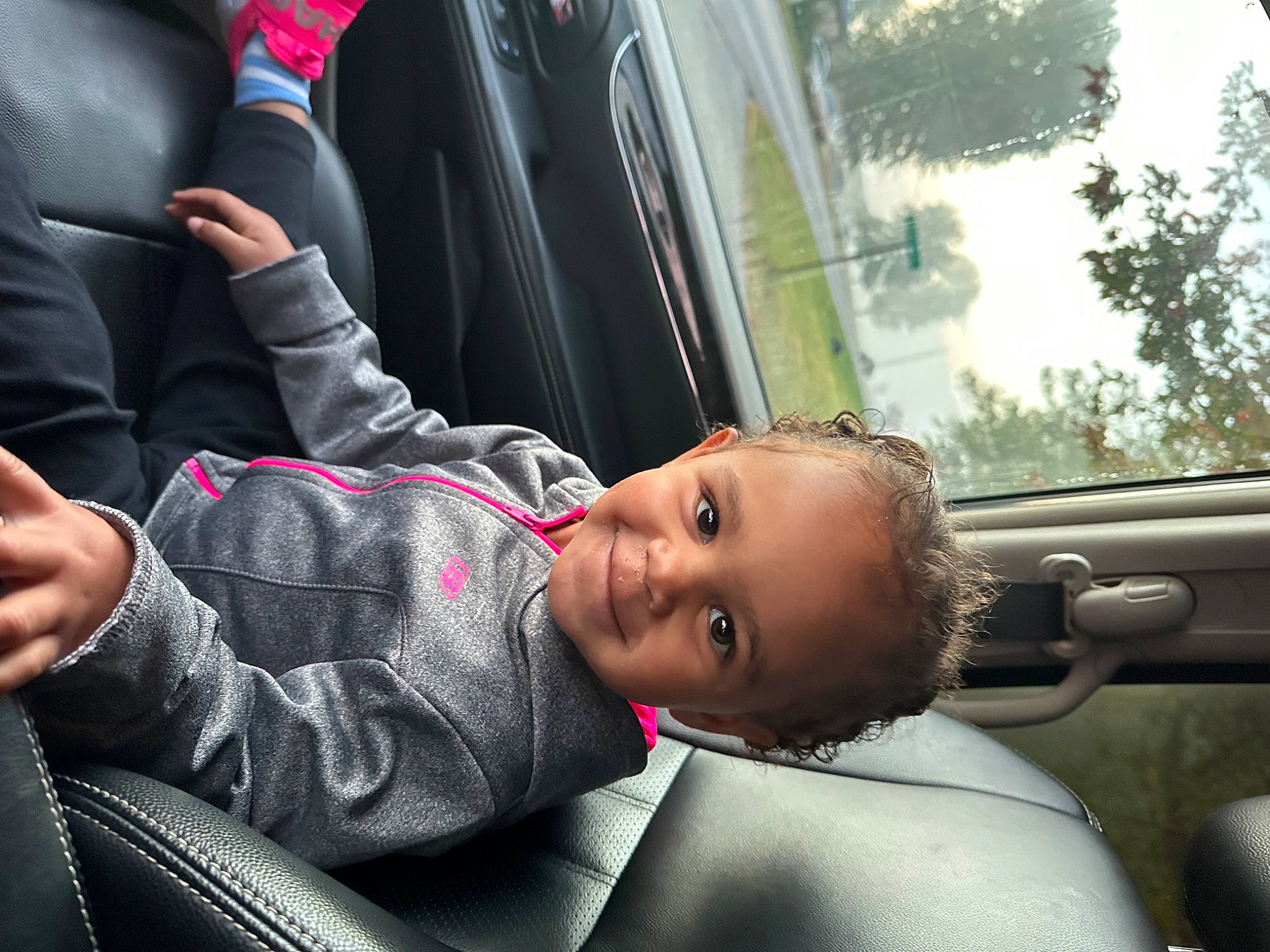 Ava is registered to the contest to win money with this photo: auto_part, automotive_design, automotive_exterior, car, car_seat, comfort, family_car, flash_photography, fun, gesture, happy, joy, mode_of_transport, motor_vehicle, person, plant, smile, toddler, tree, vehicle