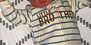 Colton is registered to the contest to win money with this photo: baby, sleeping, onesie, striped_clothing, infant, blanket, patterned_blanket, child, cute, peaceful, newborn, small_hands, footed_pajamas, indoor, resting, young_child, toddler, face, head, smiling