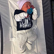 Colton is registered to the contest to win money with this photo: newborn, baby, sleeping, pacifier, hat, clothing, white, black, soft, padded_surface, socks, infant, cute, resting, indoors, closeup, tiny, peaceful, wearing, lying_down