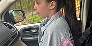 Aleigha is registered to the contest to win money with this photo: child, girl, car_interior, denim_jacket, ponytail, side_profile, passenger_seat, window, nature_outside, road_sign, seatbelt, long_hair, casual_clothing, daylight, forest, vehicle, seat, young, portrait, sitting
