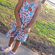 Ahna joined the competition — help win amazing prizes! child, girl, blue_bow, curly_hair, floral_dress, sparkly_shoes, sidewalk, trees, grass, sunlight, outdoor, nature, portrait, smile, standing, young, cute, fashion, playful, summer