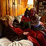 Aries is registered to the contest to win money with this photo: blanket, bookshelf, casual_clothing, couch, cozy, dog, elf_costume, happy, holiday, home, indoor, lamp, pet, pillow, reclining, remote_control, smiling, water_bottle, woman, wood_paneling