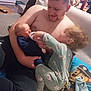 Tiago a rejoint le concours — aidez-le/la à gagner de superbes lots ! man, baby, toddler, bottle, couch, pillow, living_room, onesie, cartoon_pattern, child, feeding, family, indoor, smiling, holding, shirtless, toy, blanket, beaded_chain, floor