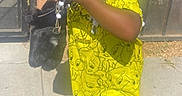 Janacia is registered to the contest to win money with this photo: child, toddler, standing, outdoor, sunlight, yellow_outfit, cartoon_pattern, braids, earrings, face_paint, sparkle, smiling, hands, finger_tasting, purse, sandal, sidewalk, patio, shadow, portrait