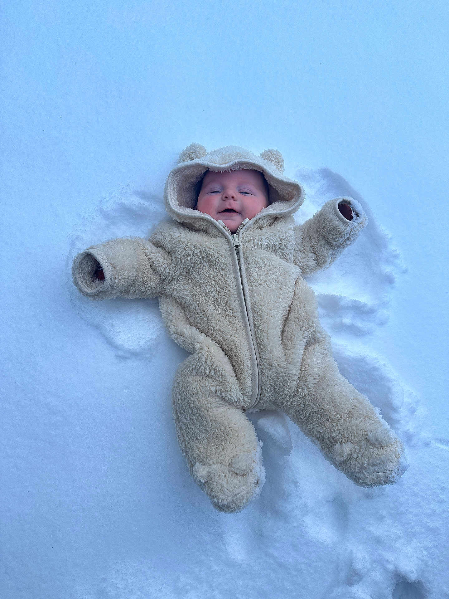 Owen joined the competition — help win amazing prizes! child, baby, infant, snow, winter, snowsuit, onesie, hood, bear_ears, outdoor, lying_down, snow_angel, smile, rosy_cheeks, cozy, warm_clothing, footprints, white_background, cold, cute