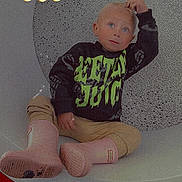 Elana is registered to the contest to win money with this photo: child, blue_eyes, blonde_hair, black_sweatshirt, neon_text, beige_pants, pink_boots, sitting, modern_chair, circular_chair, bubble_pattern, indoor, playful, fire_emojis, casual_pose, young_child, portrait, fashion, cute, expression