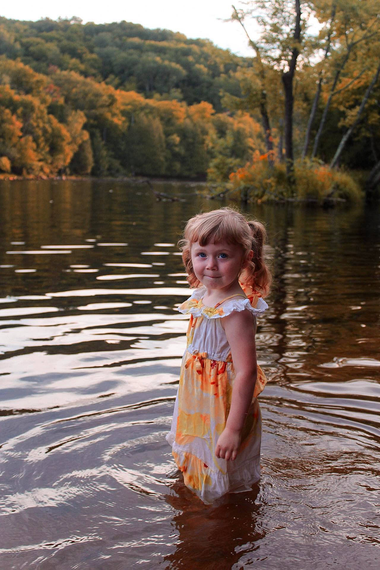 Zaria Lee is registered to the contest to win money with this photo: bank, dress, forest, fun, grass, happy, joy, lake, leaf, leisure, natural_landscape, people_in_nature, person, plant, recreation, reflection, summer, sunlight, toddler, tree