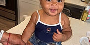 Araiya Lynn joined the competition — help win amazing prizes! baby, child, kitchen, countertop, sunglasses, denim_shorts, sneakers, smiling, holding_hand, person, indoor, modern_kitchen, appliance, sink, stove, cute, fashion, happy, infant, footwear