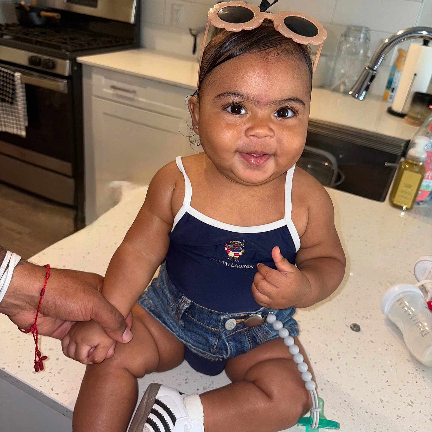 Araiya Lynn joined the competition — help win amazing prizes! appliance, baby, child, countertop, cute, denim_shorts, fashion, footwear, happy, holding_hand, indoor, infant, kitchen, modern_kitchen, person, sink, smiling, sneakers, stove, sunglasses