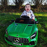 Emma a rejoint le concours — aidez-le/la à gagner de superbes lots ! automobile, baby, blue_sky, child, daylight, excited, grass, green_car, happy, hoodie, nature, outdoor, person, play, small_car, smile, toy_car, trees, vehicle, young_child