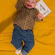 Ezio participe au concours pour gagner de l'argent avec cette photo : baby, casual, celebration, checkered_shirt, child, clothing, cute, feet, happy, indoor, infant, jeans, lying_down, milestone_card, person, portrait, raised_arms, smiling, socks, yellow_blanket