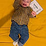 baby, casual, celebration, checkered_shirt, child, clothing, cute, feet, happy, indoor, infant, jeans, lying_down, milestone_card, person, portrait, raised_arms, smiling, socks, yellow_blanket