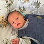 baby, newborn, infant, cushion, animal_print, lying_down, clothing, quilted_vest, hand, face, eyes_open, indoor, cozy, soft_fabric, toddler, cute, comfort, nursery, child, portrait