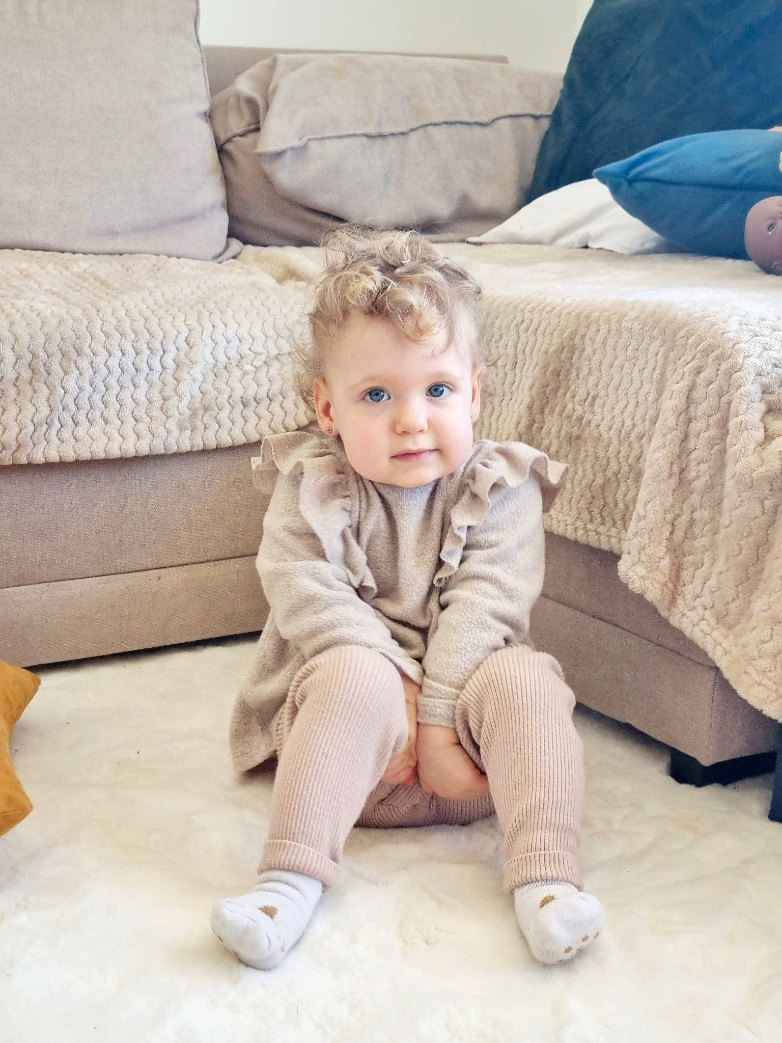 Fiona participe au concours pour gagner de l'argent avec cette photo : baby, baby_toddler_clothing, child, comfort, couch, floor, flooring, foot, furniture, hair, hardwood, human_leg, linens, living_room, person, pillow, sitting, sleeve, textile, toddler