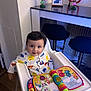 Chaieb Noah participe au concours pour gagner de l'argent avec cette photo : baby, high_chair, toy, book, pajamas, sesame_street, colorful, face, smile, indoor, wooden_floor, kitchen, counter, figurines, family_photo, child, person, furniture, happy, playtime