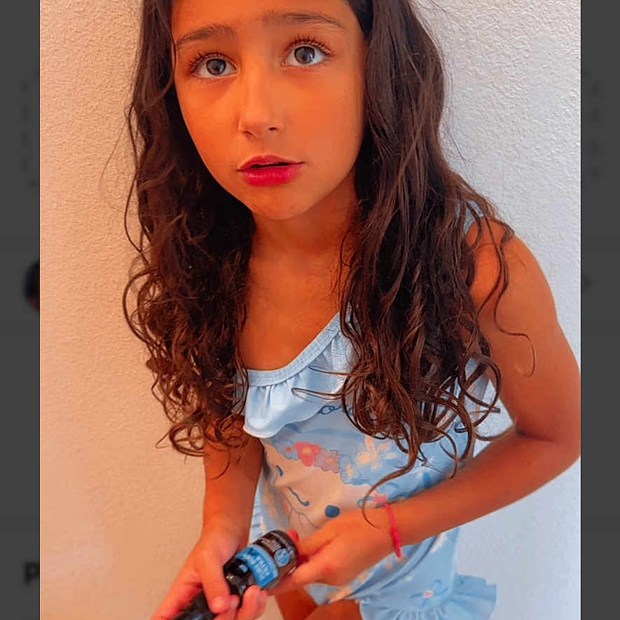 Blair joined the competition — help win amazing prizes! child, girl, portrait, curly_hair, long_hair, brown_hair, blue_eyes, dress, fashion, pose, indoors, staircase, wall, wood, handheld_object, smiling, serious_expression, photograph, website_screenshot, voting