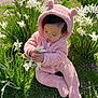 baby, child, curious, cute, daylight, flowers, fluffy_clothing, garden, grass, greenery, hood_with_ears, nature, outdoor, pink_onesie, playing, sitting, spring, sunlight, toddler, white_flowers