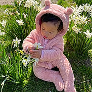 Araya joined the competition — help win amazing prizes! baby, child, curious, cute, daylight, flowers, fluffy_clothing, garden, grass, greenery, hood_with_ears, nature, outdoor, pink_onesie, playing, sitting, spring, sunlight, toddler, white_flowers