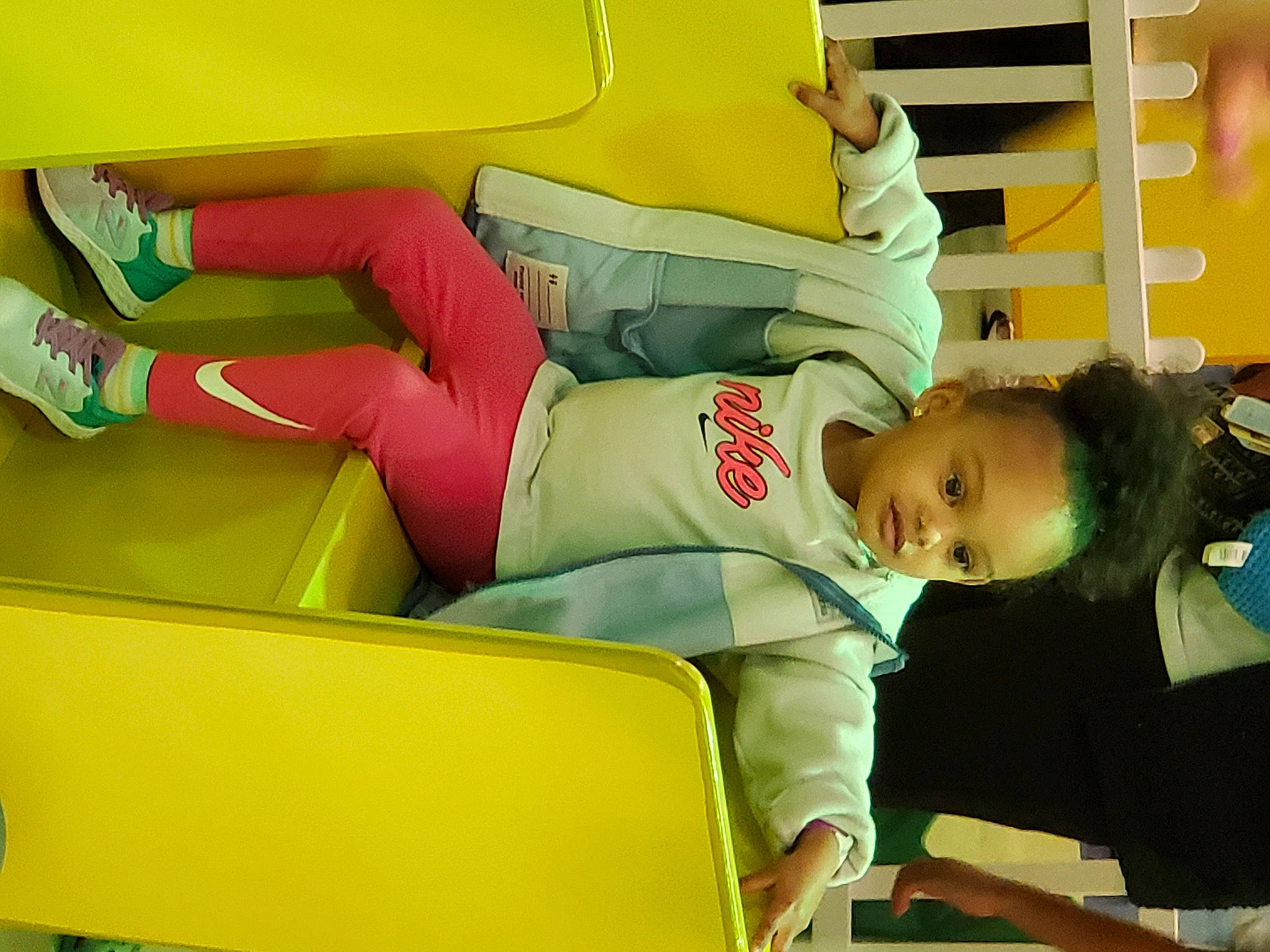 Harmony is registered to the contest to win money with this photo: automotive_design, child, comfort, fashion_design, foot, fun, human_leg, knee, lap, leisure, person, recreation, room, sandal, shorts, sitting, sportswear, t_shirt, thigh, yellow