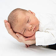 Mylan participe au concours pour gagner de l'argent avec cette photo : newborn, baby, sleeping, hand, white_clothing, infant, peaceful, portrait, closeup, skin, adult_hand, resting, soft_light, tender, cute, child, human, young, sleep, cozy