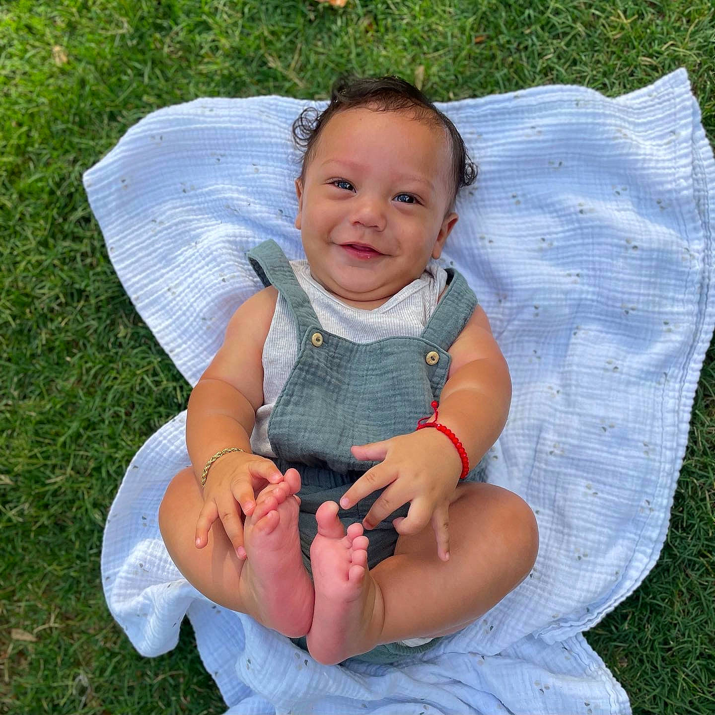 Eddie is registered to the contest to win money with this photo: baby, baby_toddler_clothing, barefoot, comfort, eye, face, fun, gesture, grass, happy, head, joy, lap, lawn, leisure, pattern, people_in_nature, person, product, skin